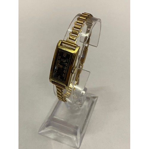 166 - A lady's Swiss wristwatch with rectangular black enamel dial, in a 14kt. gold case, on a 9ct. gold b... 