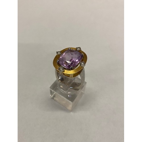 176 - A lady's ring set centre amethyst with small brilliant cut diamond to each side, in a brushed 18kt. ... 