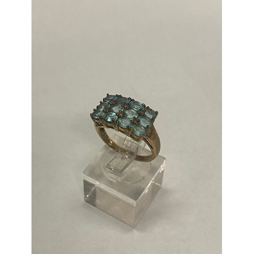 183 - A lady's ring set three bands of four pale blue stones, on a 9ct. gold shank