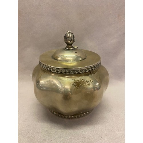 145 - A silver tea caddy of shaped oval form, flame form finial to the hinged lid - London 1910, makers ma... 