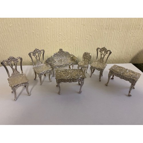 152 - Five miniature silver models of chairs with repousse decoration of putti to the seats, a pair of sim... 