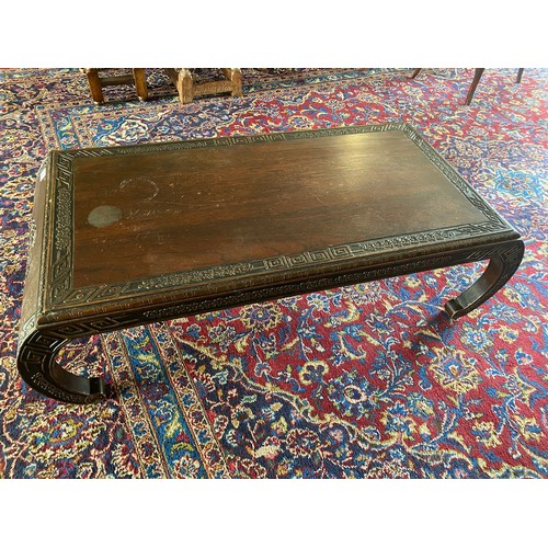 78 - A carved Chinese hardwood opium table with carved decoration, on scroll ends - 43in. wide