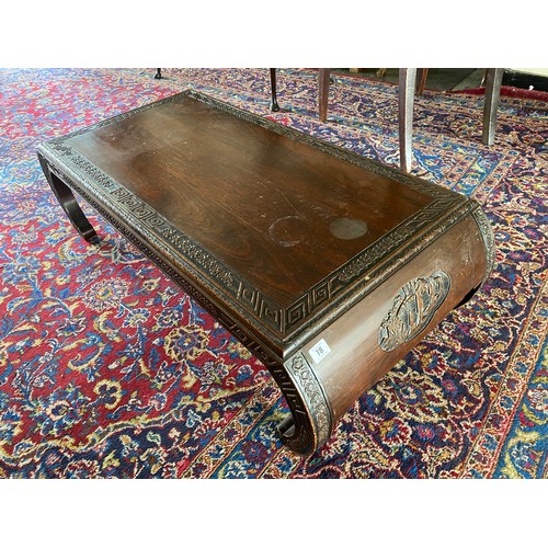 78 - A carved Chinese hardwood opium table with carved decoration, on scroll ends - 43in. wide