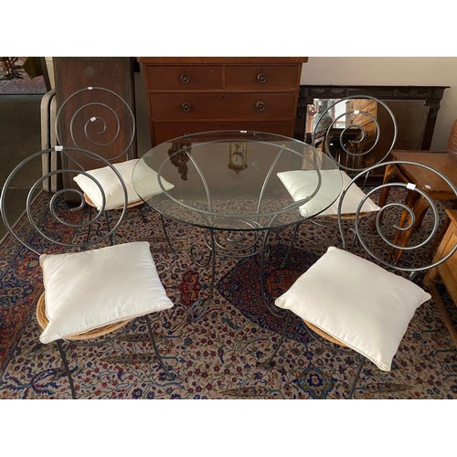 64 - A small glass topped table on brushed steel base - 35 1/2in. dia.  and four matching chairs