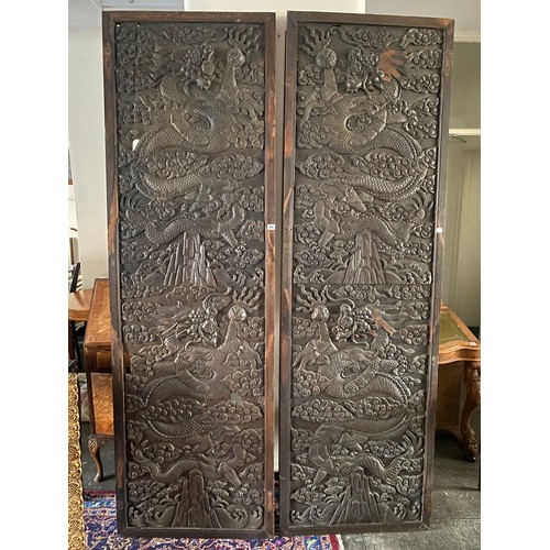 247 - A pair of Chinese carved panels depicting dragons chasing the golden pearl in relief - 89in. x 27 1/... 