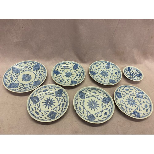 114 - Seven 18th Century Chinese graduated plates decorated with stylised flowers in blue and white - 6 3/... 