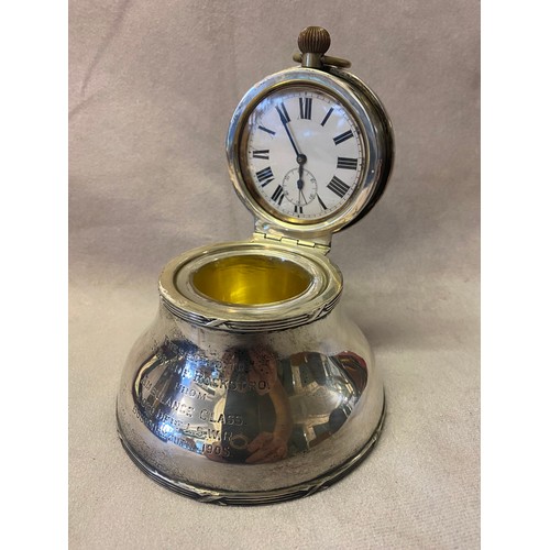 195 - An Edwardian silver desk inkwell, the hinged lid with inset pocket watch with white enamel dial and ... 