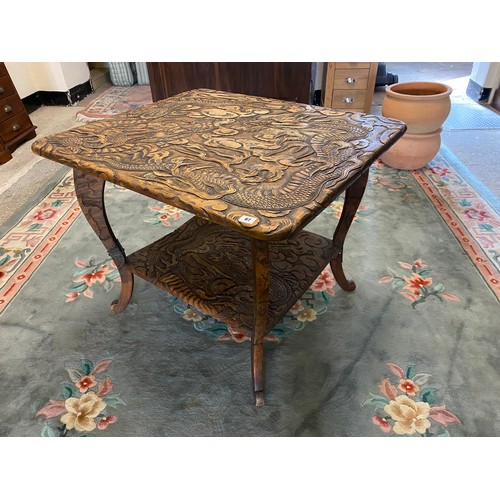 67 - A large Japanese softwood table with carved decoration to the top and undertier of dragons retailed ... 