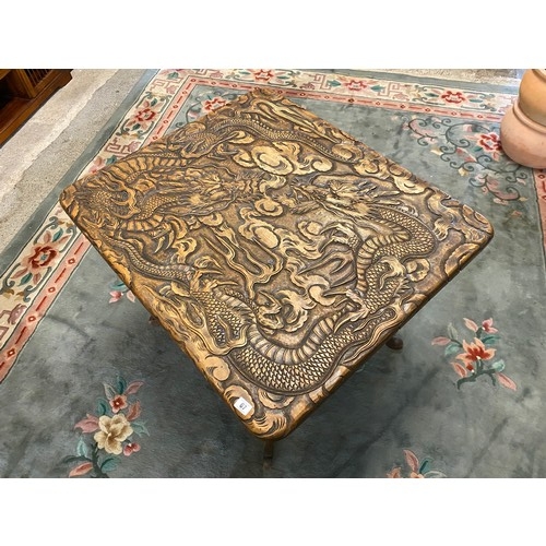 67 - A large Japanese softwood table with carved decoration to the top and undertier of dragons retailed ... 