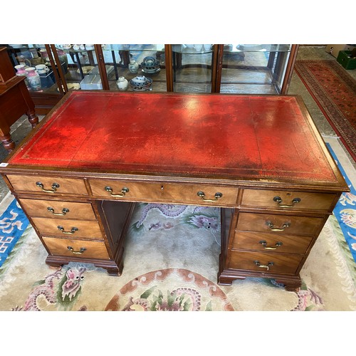 30 - A mahogany desk with red and gilt tooled leather writing surface, three frieze drawers, three drawer... 