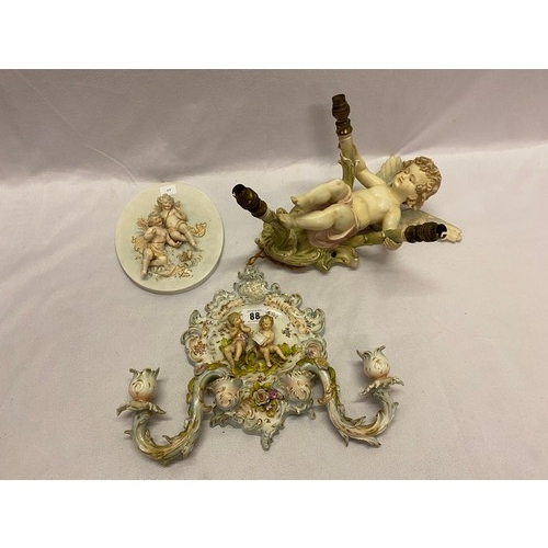 88 - A Continental porcelain twin branch wall light in the form of a cupid, a twin branch wall bracket wi... 