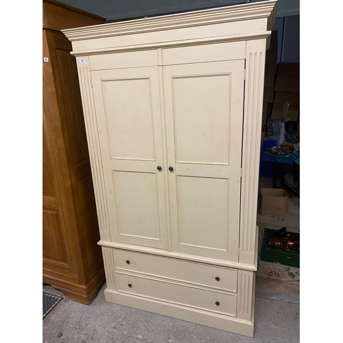 65 - A modern painted pine wardrobe fitted two panelled doors, fluted sides, the base fitted two drawers ... 