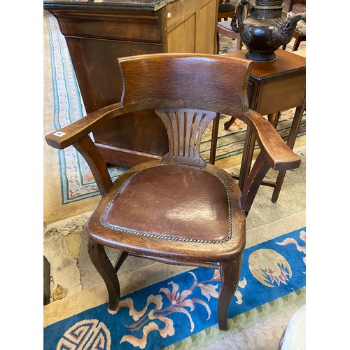 64 - An oak desk chair with curved cresting rail, pierced centre splat, inset leather seat, on cabriole s... 