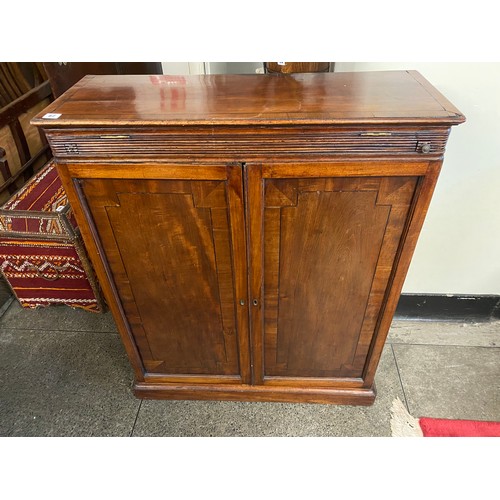 62 - A 19th Century mahogany cabinet with sliding hinged writing surface above two panelled doors, on pla... 