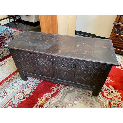 55 - An antique oak coffer with hinged lid enclosing candle box, the front with four carved panels - 54in... 