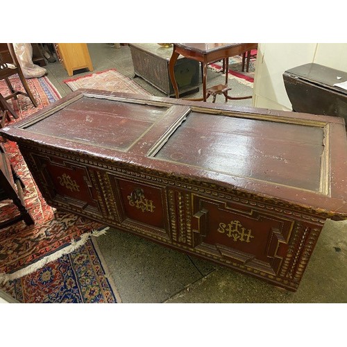 113 - A Continental stained pine coffer with hinged panelled lid, three panels with stylised decoration to... 