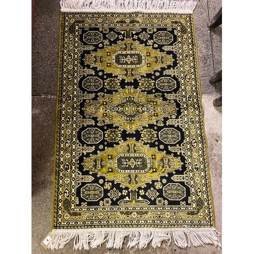 4 - An Eastern rug, black and green field decorated three medallions to the centre, multi bordered, frin... 