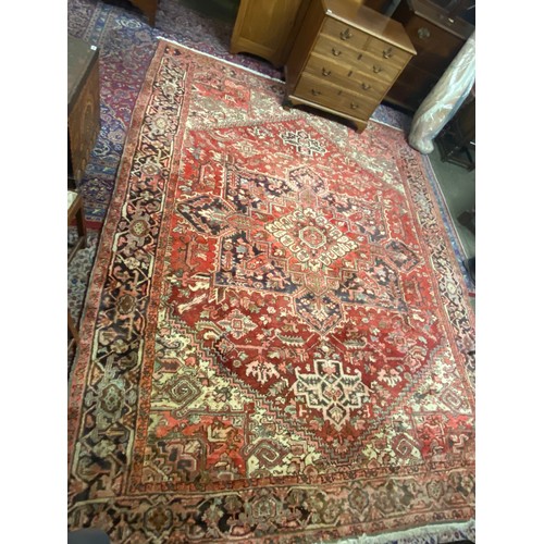 2 - An Eastern carpet, red field with cream, red and black medallion centre, stylised border, fringed - ... 