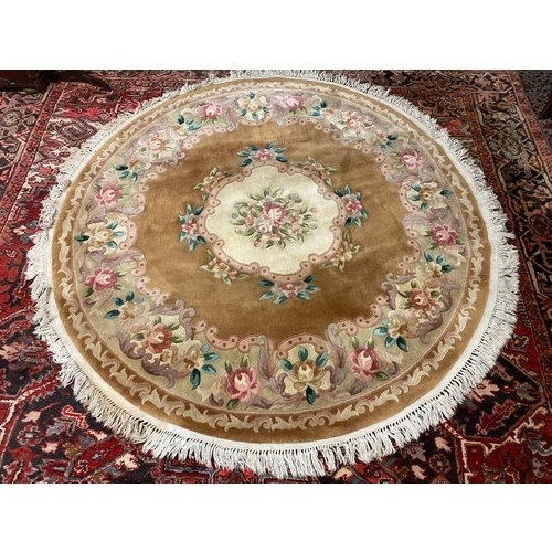 7 - A circular Chinese rug, beige field with repeating floral pattern, fringed - 73in. dia.