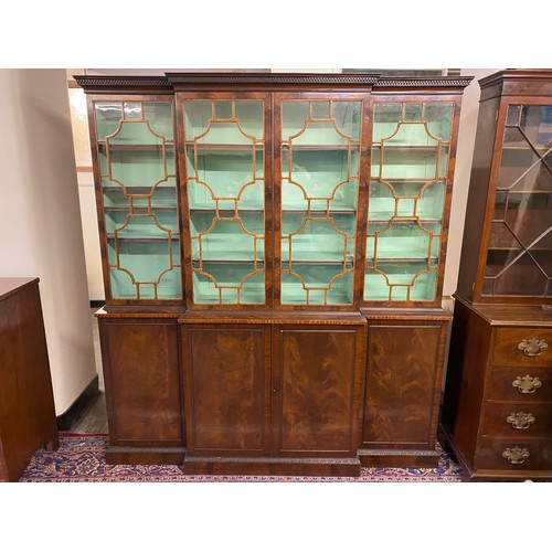 46 - A mahogany breakfront bookcase, the upper part fitted glass doors, the base fitted panelled doors, o... 