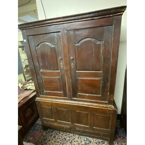 109 - An antique oak cupboard, the upper part fitted two shaped panelled doors, the base fitted four panel... 