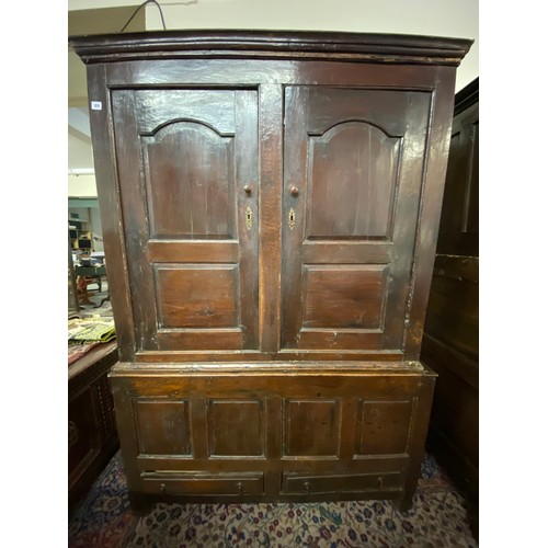 109 - An antique oak cupboard, the upper part fitted two shaped panelled doors, the base fitted four panel... 