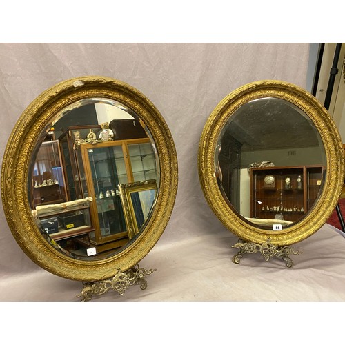 56 - A pair of oval bevelled wall mirrors in gilt frames - 24in. x 20in.