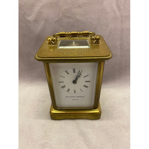 260 - A modern carriage clock retailed by Matthew Norman, white enamel dial, in a brass and glass case wit... 