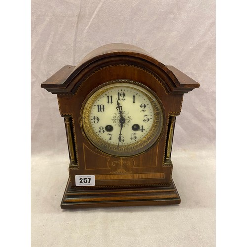 257 - An Edwardian mantel clock, cream enamel dial, striking movement on a gong, in a mahogany and satinwo... 