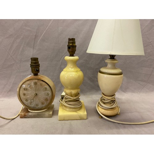 242 - A mantel clock/tablelamp base with circular dial, in an alabaster case and two alabaster tablelamp b... 