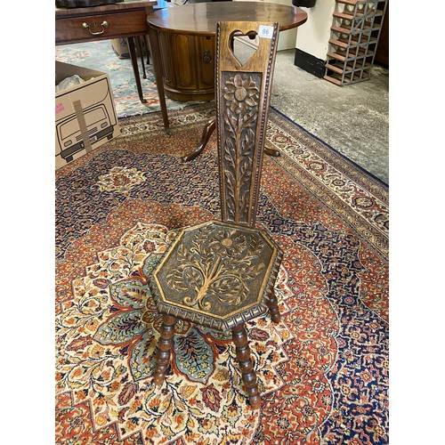 96 - An oak spinning chair with carved flowers and leaves to the back and seat, on bobbin turned legs