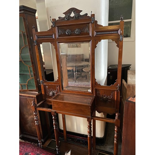 89 - An Edwardian walnut hallstand with carved flower and leaf decoration, fitted centre bevelled mirror ... 