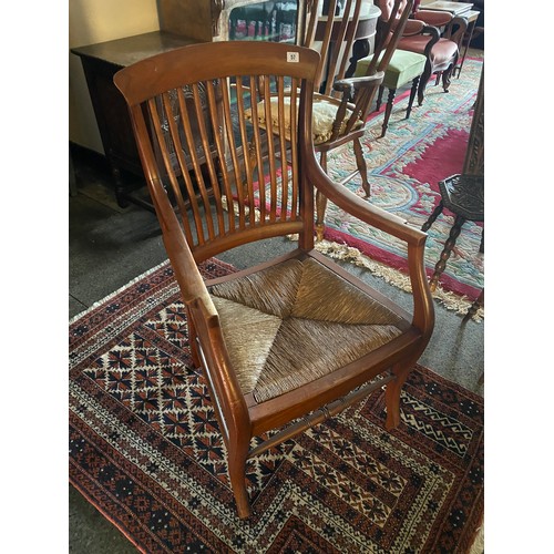 57 - A walnut framed desk chair with comb back, rush seat, on scroll legs