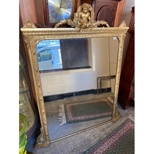 39 - A large Victorian overmantel in a gilt frame with cupid and laurel wreath decoration - 55in. x 45in.