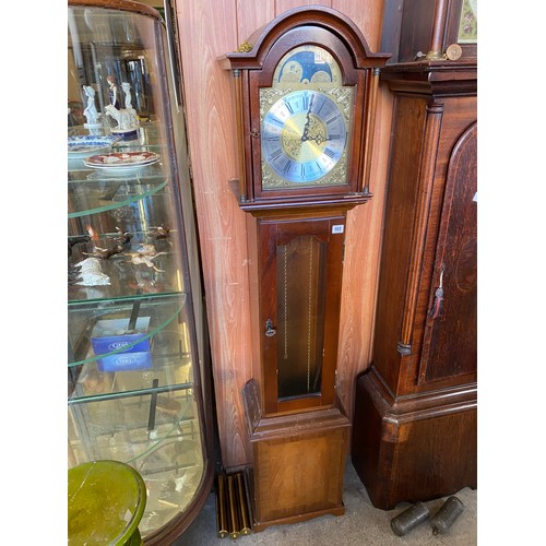 102 - A reproduction longcase clock with brass dial, silvered chapter ring, moon phase to the arch, in a m... 