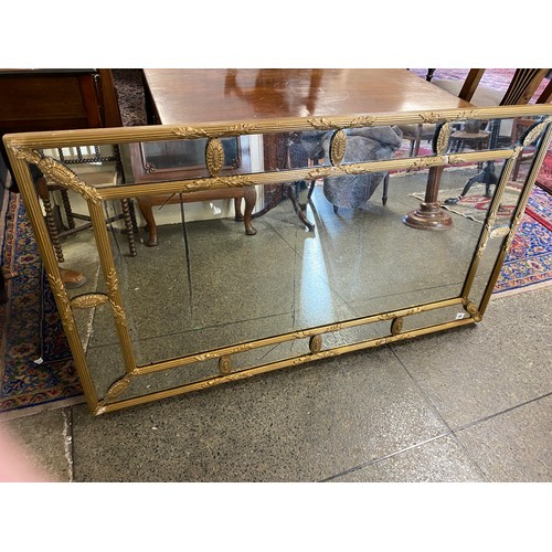 43 - A 19th Century rectangular sectional wall mirror in a gilt frame with paterae - 29in. x 51in.