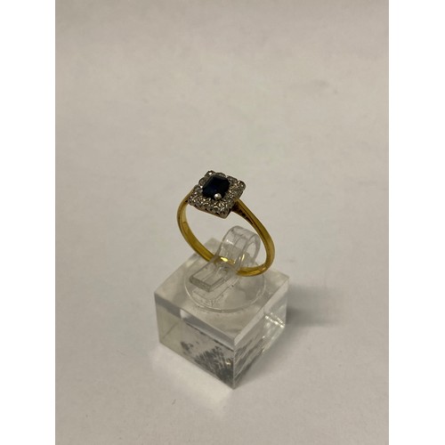 268 - A lady's ring, the top set centre sapphire surrounded by illusion set diamonds, on an 18ct. gold and... 