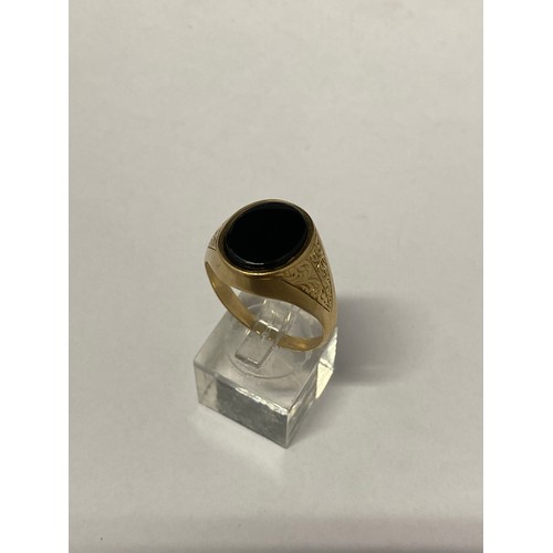 264 - A gentleman's signet ring, the top set onyx, on a 9ct. gold shank with engraved shoulders