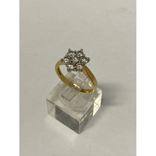 260 - A lady's ring of flower form set seven diamonds, on an 18ct. gold shank