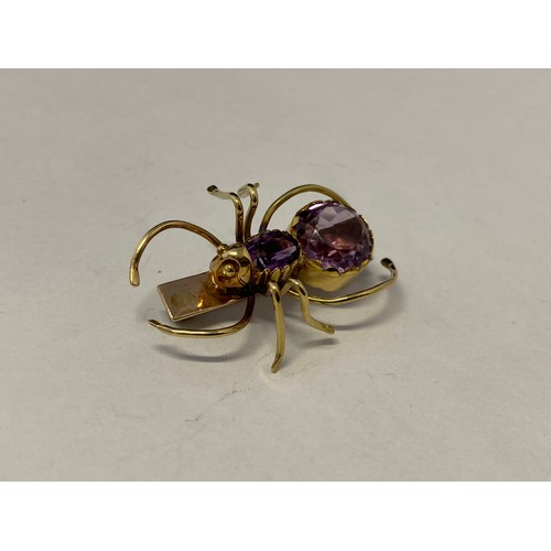 233 - A gold coloured metal brooch in the form of a bug with amethyst set body, in fitted box