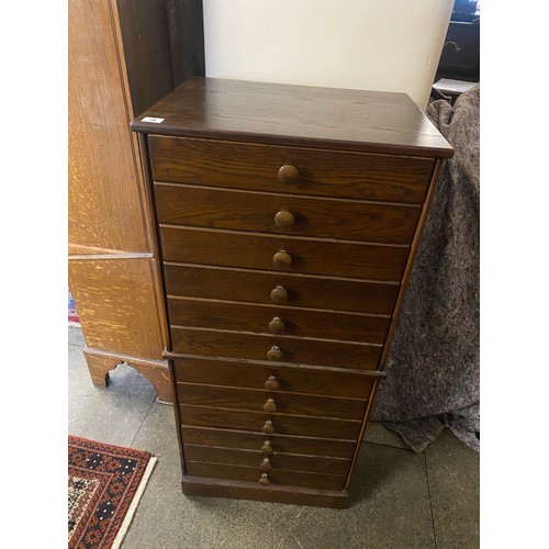 78 - A John Austen oak sheet music cabinet fitted twelve drawers, turned wood knob handles - 20in. wide