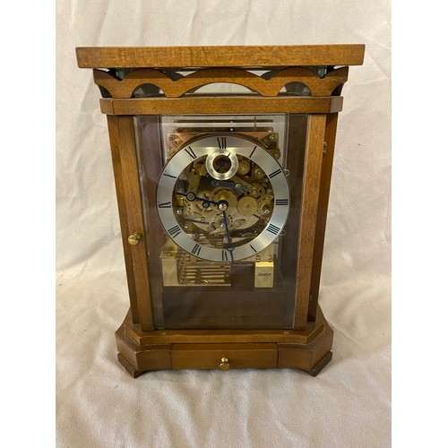 314 - A modern brass Keninger mantel clock with silvered dial, striking on gongs, in a mahogany and glass ... 