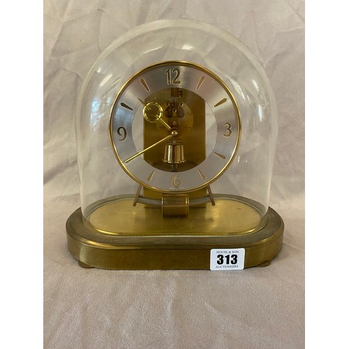 313 - A German Kundo mantel clock in a brass case, under a glass dome - 9 1/2in. high