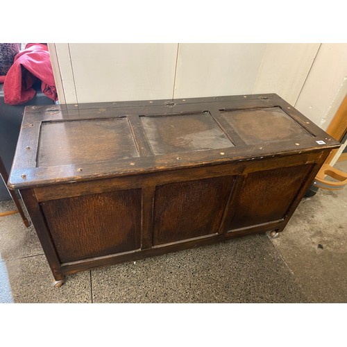 43 - An oak coffer with hinged panelled lid and front - 48in. wide