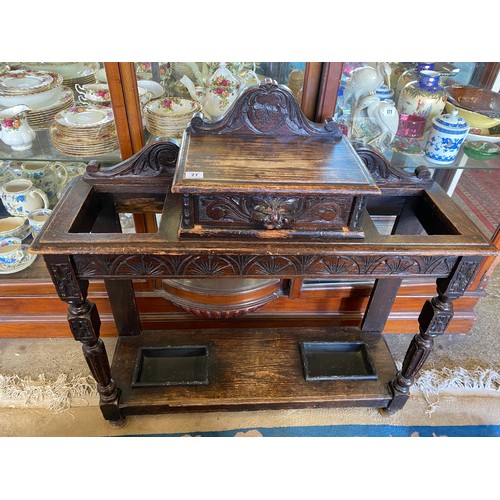 27 - A Victorian oak hallstand with low raised back, glove box with lion mask handle, fluted supports and... 