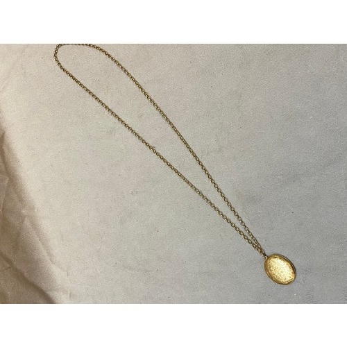 251 - An oval 9ct. gold locket with engraved decoration, on a 9ct. gold chain