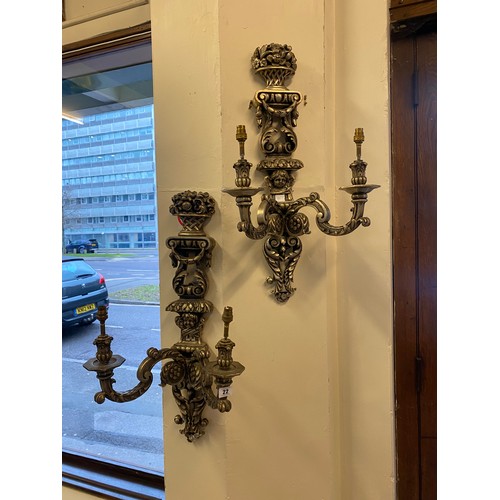 22 - A set of three silver sprayed twin branch wall lights with baskets of flowers to the tops and putti ... 