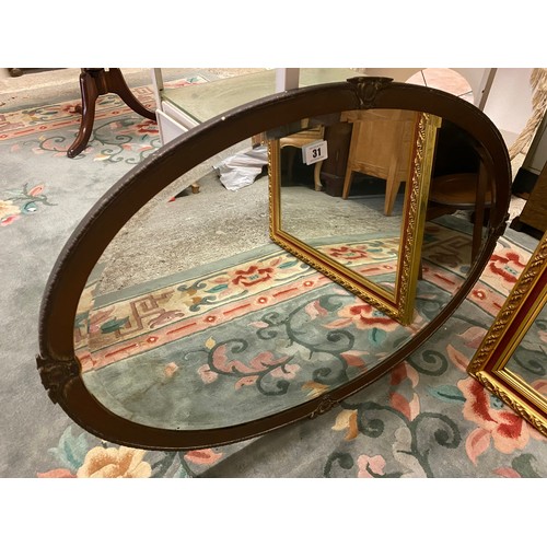 31 - An oval bevelled wall mirror in a decorative copper frame- 32in. x 22in.