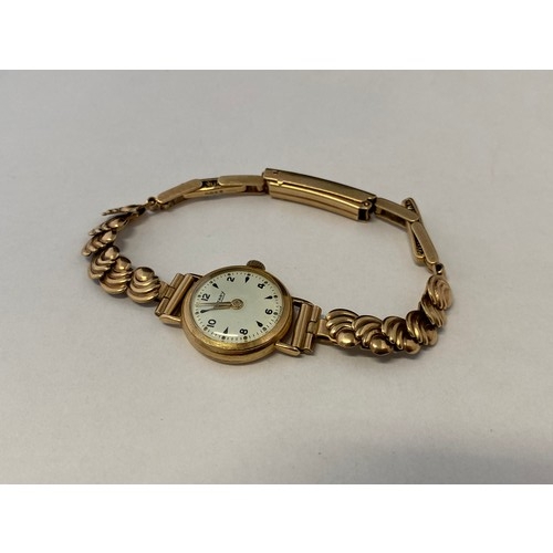 235 - A lady's Rotary wristwatch with white enamel dial, in a 9ct. gold case, on a 9ct. gold bracelet