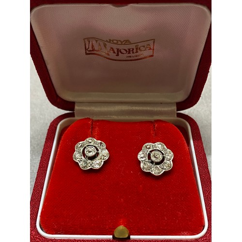 251 - A pair of diamond set flower form cluster earrings, mounted in white gold